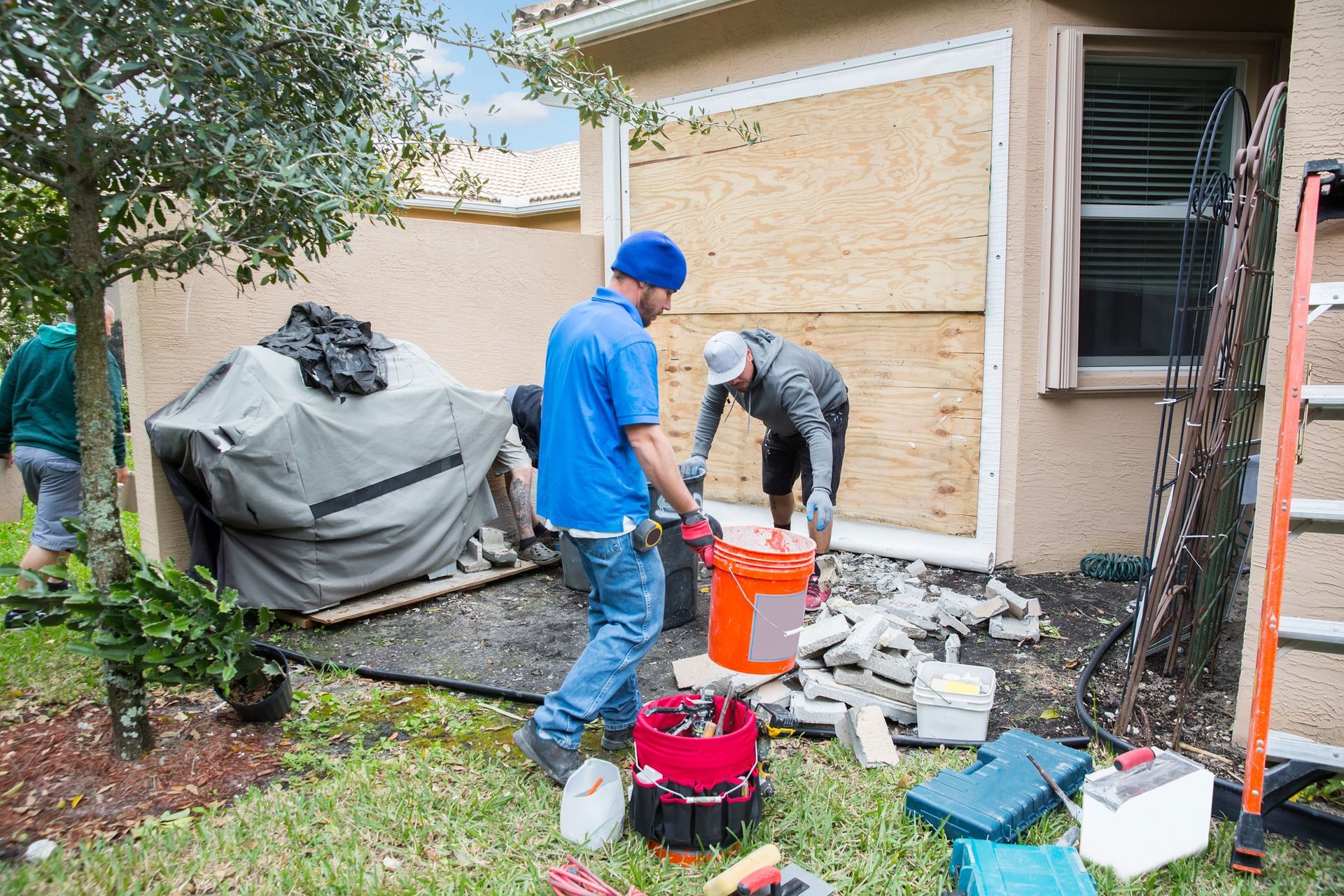 A Group Of Men Are Working On A House — Aiken, NC — Aiken Junkmaster