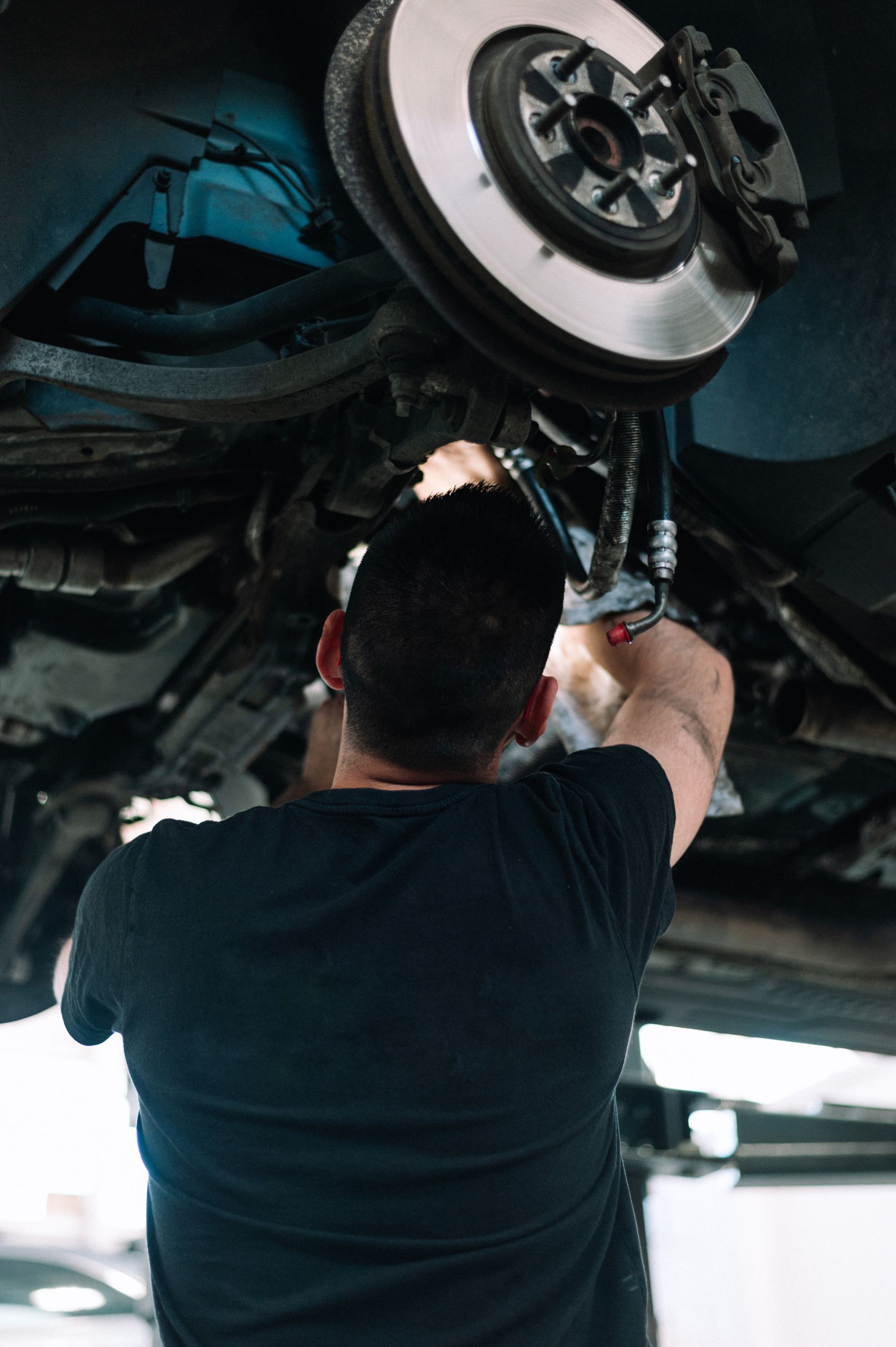 A red car's wheel's alignment are being checked at the garage.