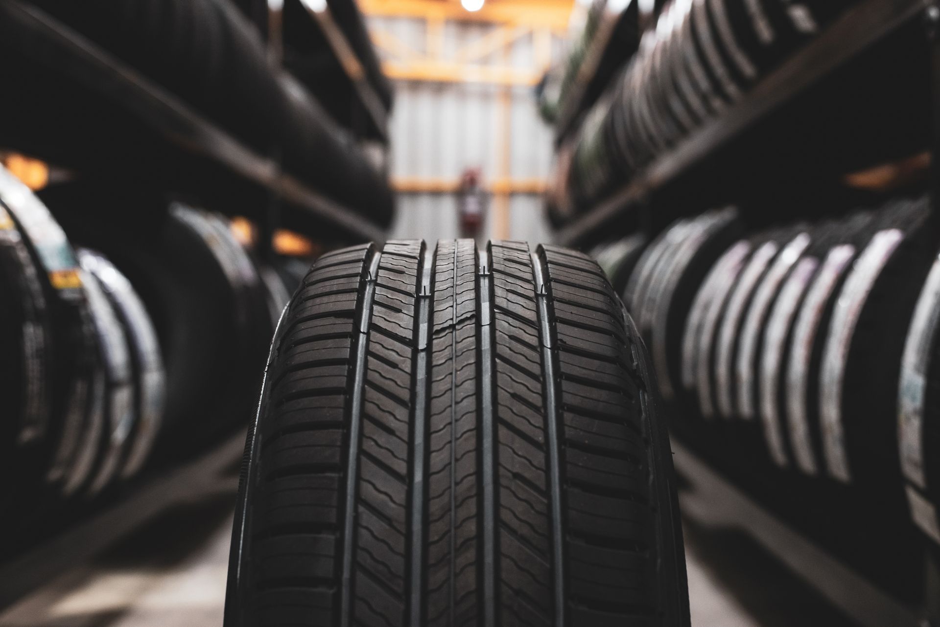 A close up of a tyre in between shelves stocked with tyres