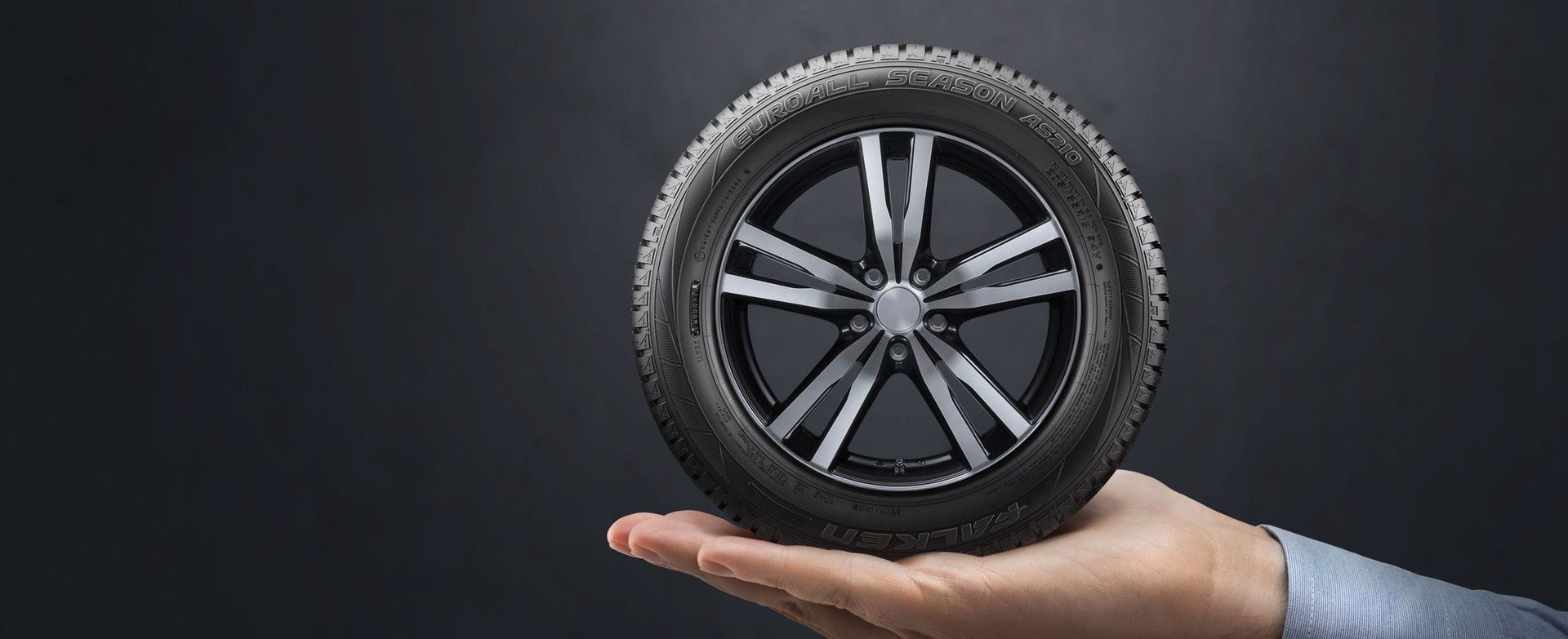 man holding black tyre in palm of his hand