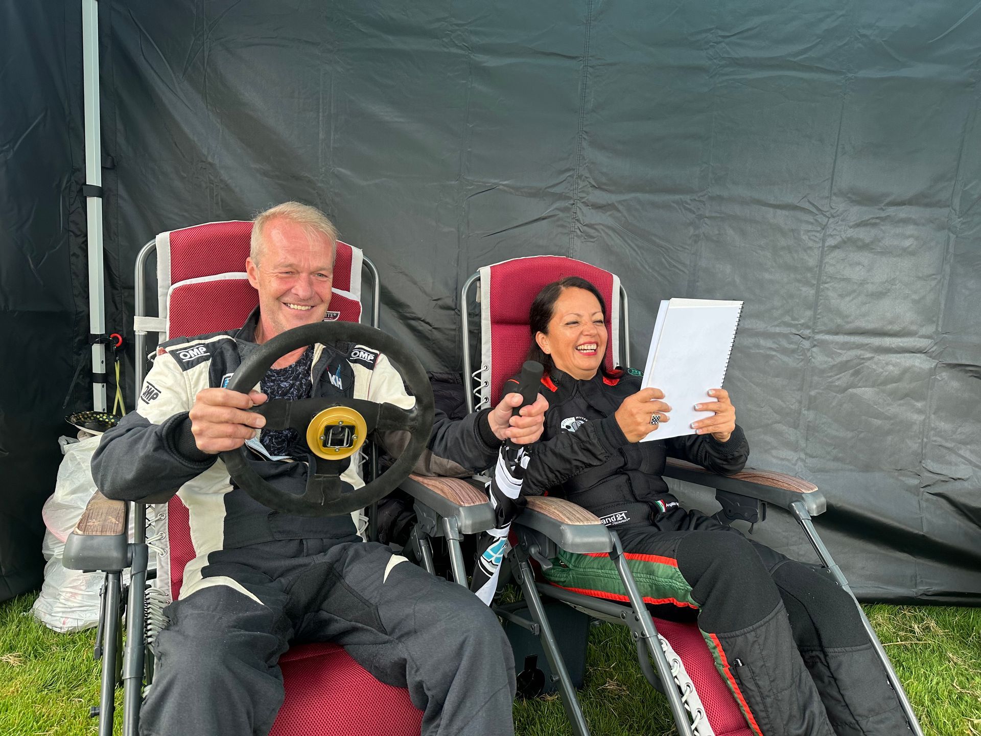 Two rally drivers relaxing on garden chairs at the rally festival
