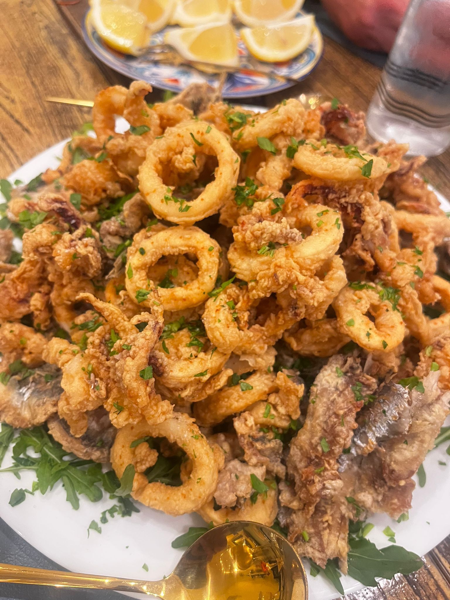 Un piatto di calamari fritti e altri frutti di mare su un tavolo.