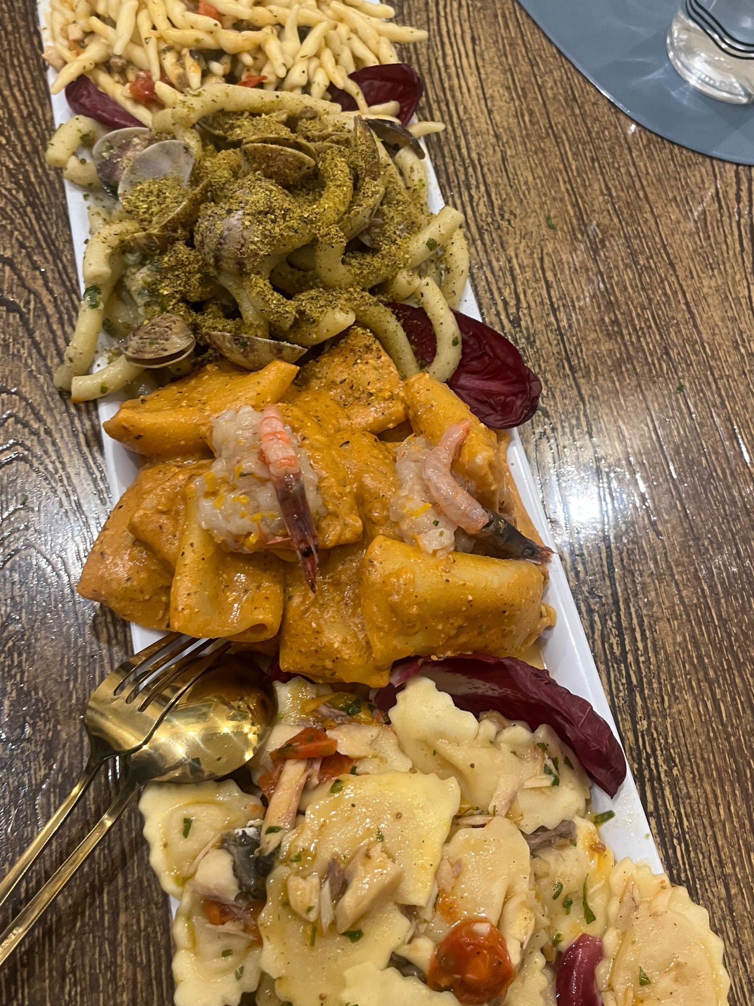 Un piatto bianco con sopra vari cibi su un tavolo di legno.