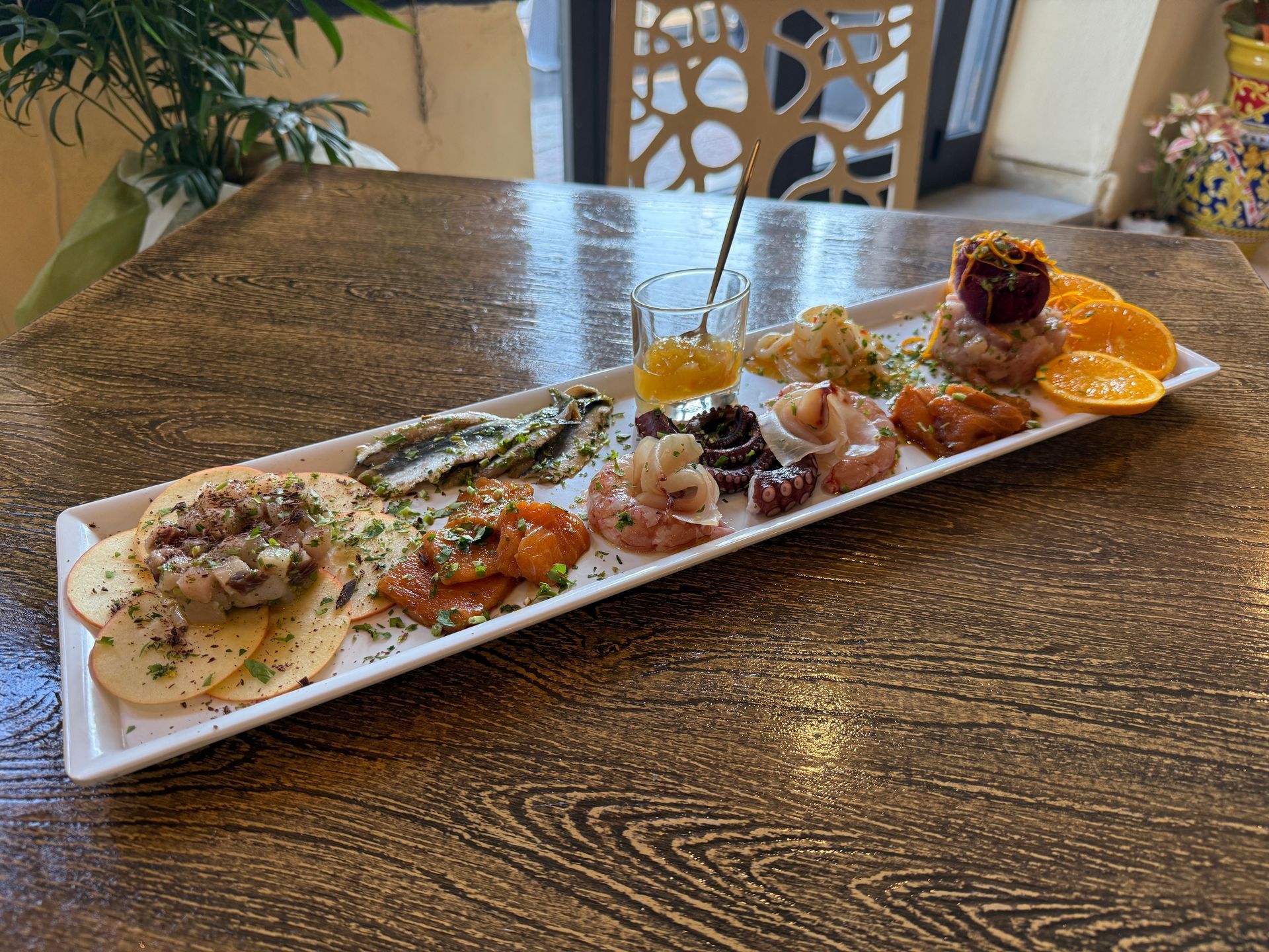 Un lungo piatto di cibo è appoggiato su un tavolo di legno.