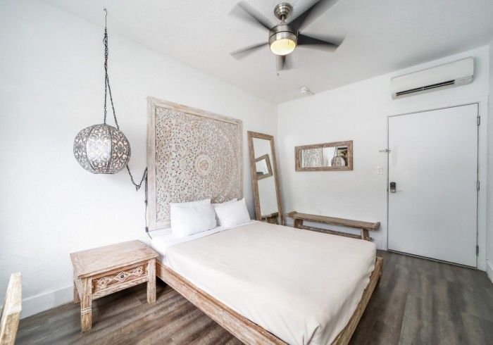 Bedroom with bed, ornate headboard, wooden furniture, and gray flooring.