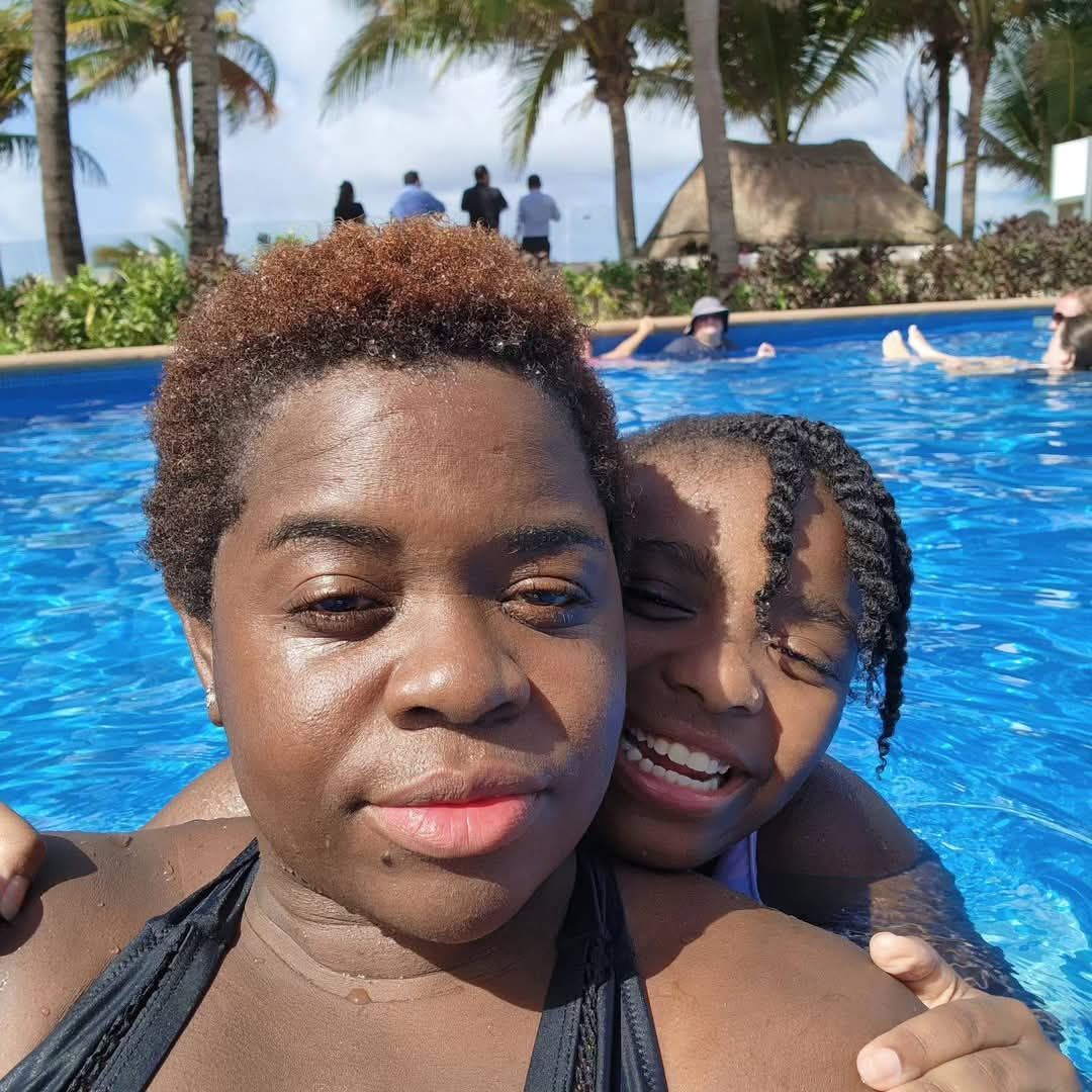 A wooden door with a black handle is behind a black fence.