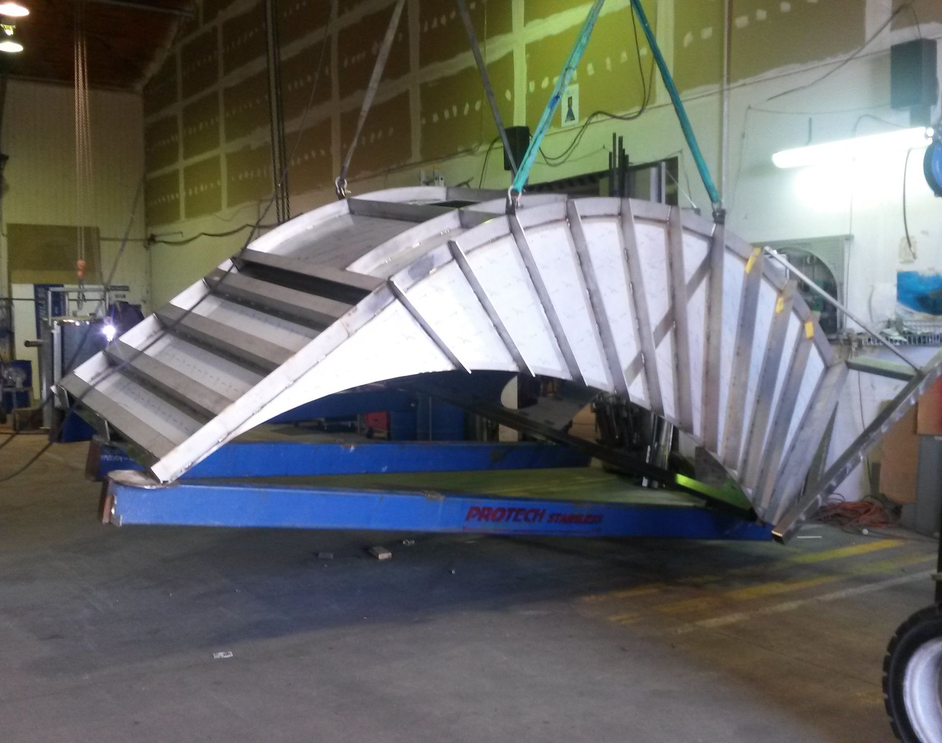 Industrial packaging line with conveyor, multi-head weigher, and packaging machine. Worker in white protective gear.