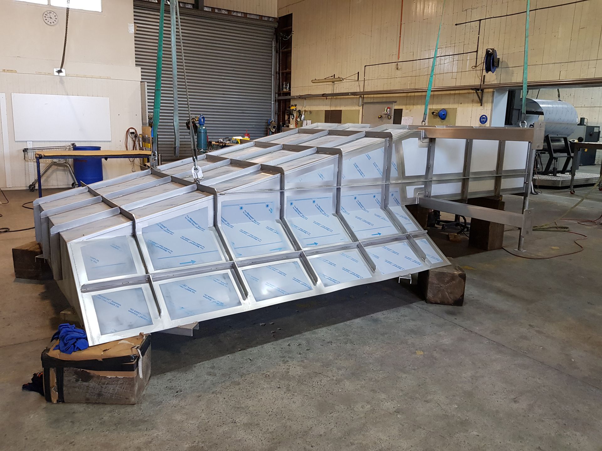 Metal structure with a series of rectangular panels in a workshop setting.