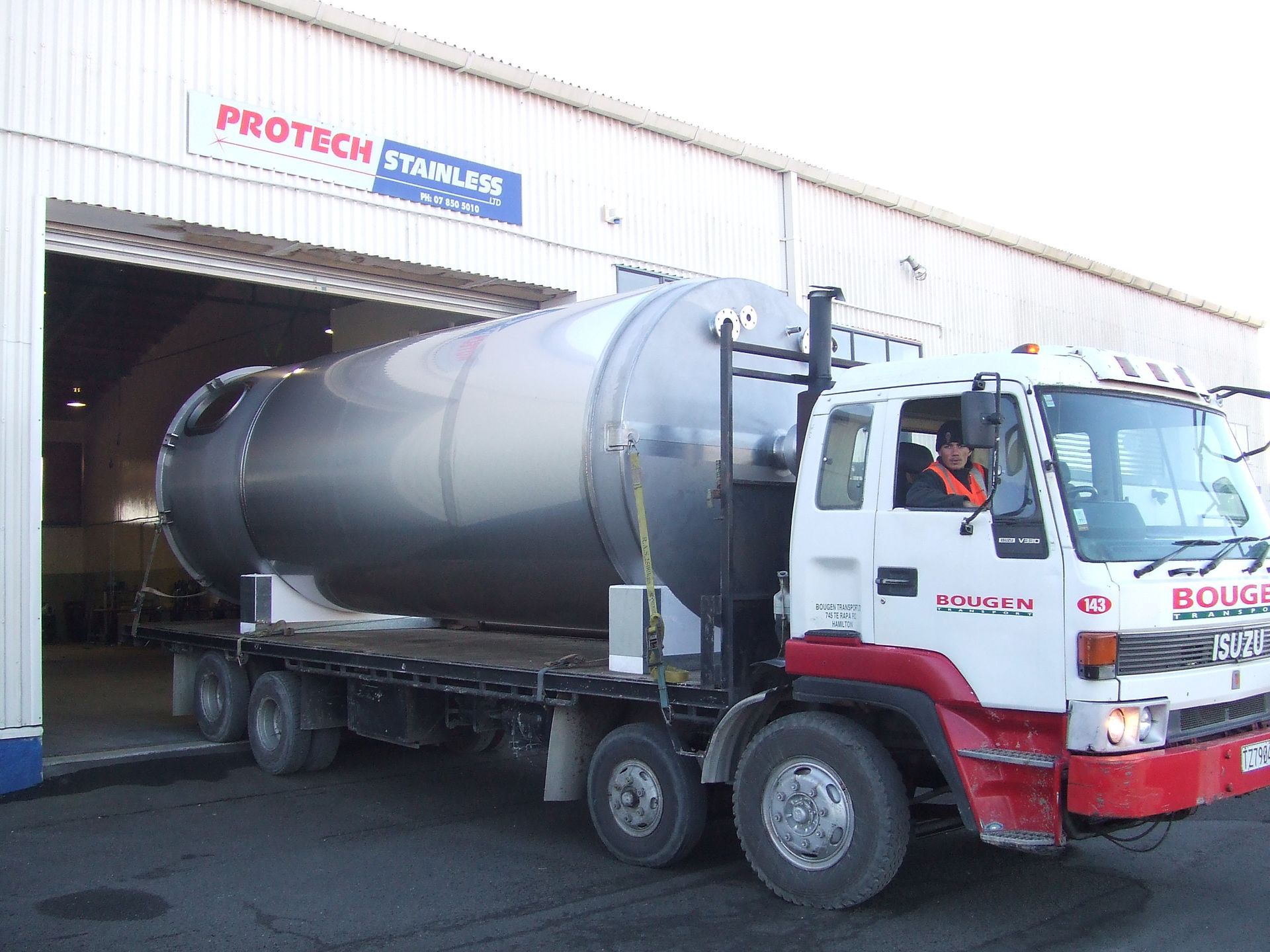 Stainless steel industrial water filtration system in a workshop setting.