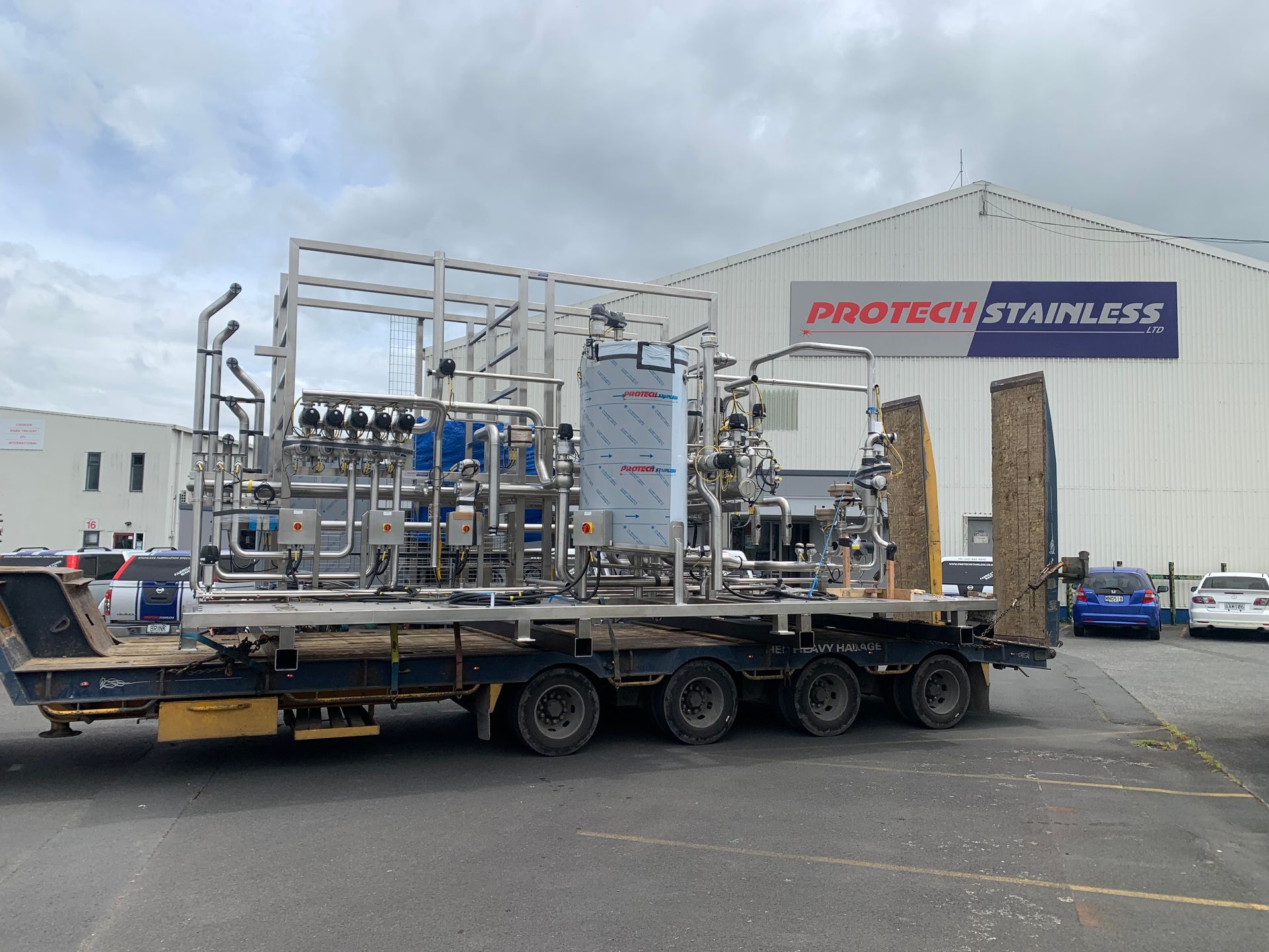 Stainless steel industrial equipment on a flatbed truck in front of the 