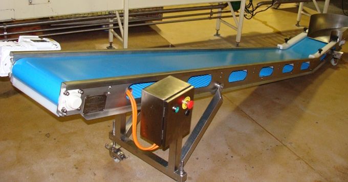 Blue conveyor belt in a factory setting, with a metal frame and electrical control box.