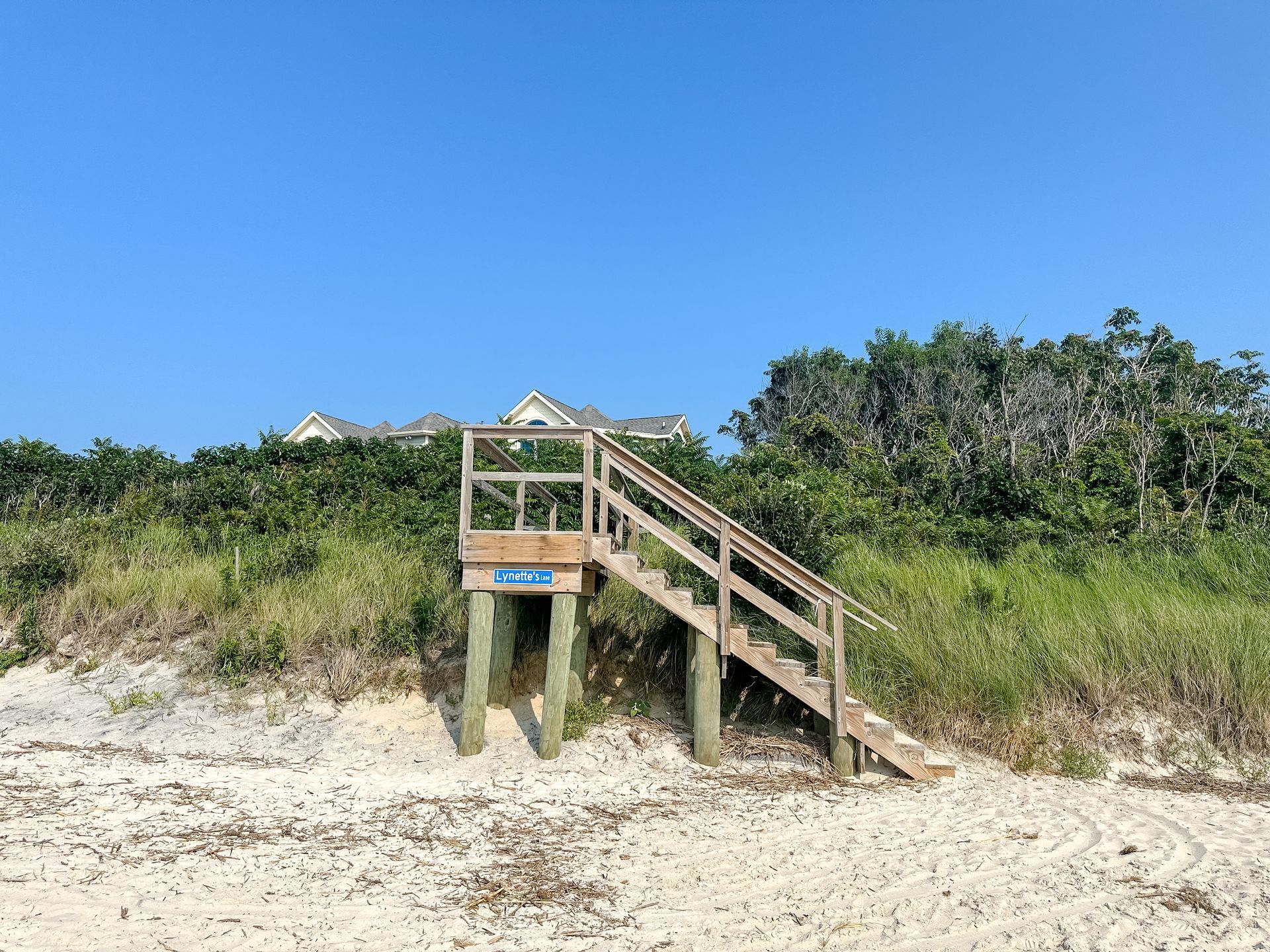a wooden staircase leading up to a house on the beach