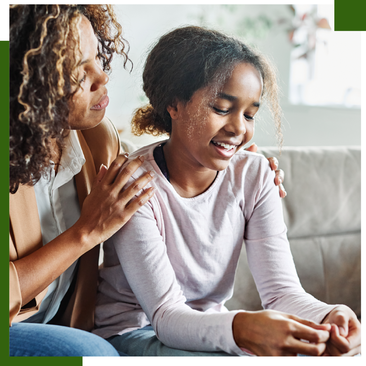 Woman comforting a person with a hand on the shoulder; both appear calm inside a home.