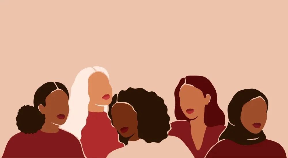 Five women in various skin tones stand together, all facing forward. Beige background, red/burgundy clothing.