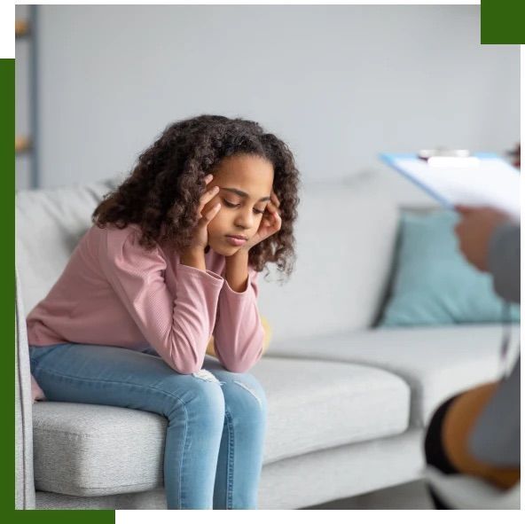 Girl sitting on a couch distressed, during a therapy session.
