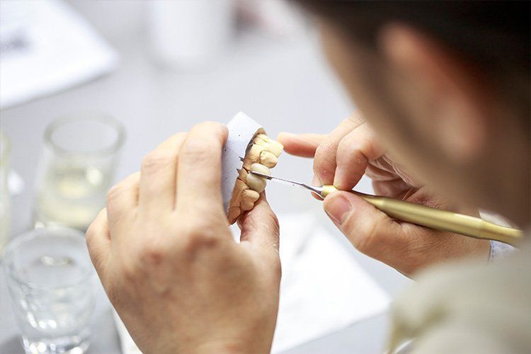 A dentist working on a teeth model | Dental Services in Cincinnati