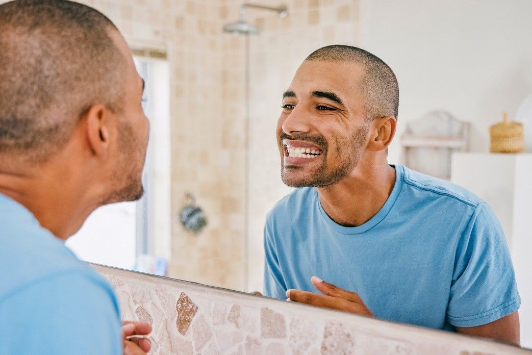 man checking his teeth in the mirror