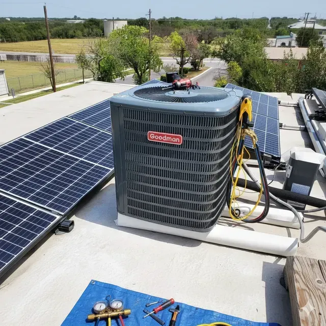 HVAC unit on a roof with solar panels and repair tools.