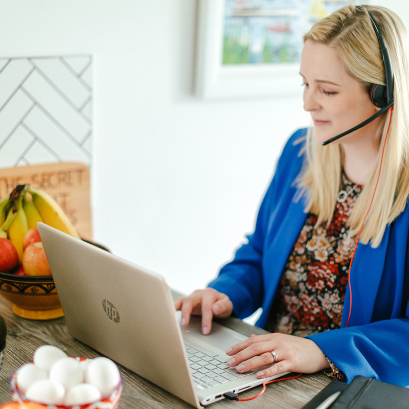 A woman wearing headphones is using an hp laptop