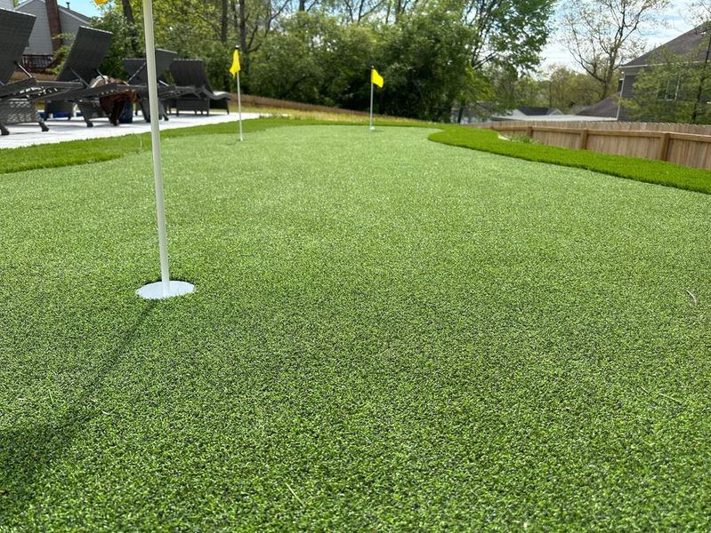 A golf course with a yellow flag on the green.