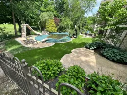 A large backyard with a swimming pool and a slide.