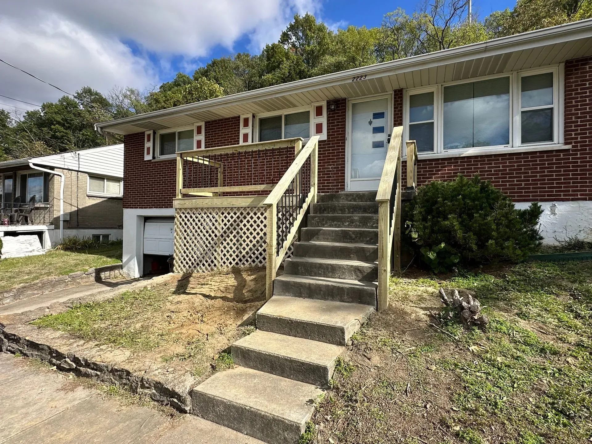 A brick house with stairs leading up to the front door.