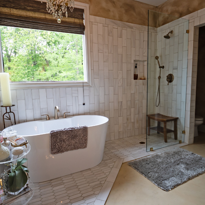 A modern bathroom featuring a white freestanding tub, a walk-in shower with vertical white tile, and a large window.