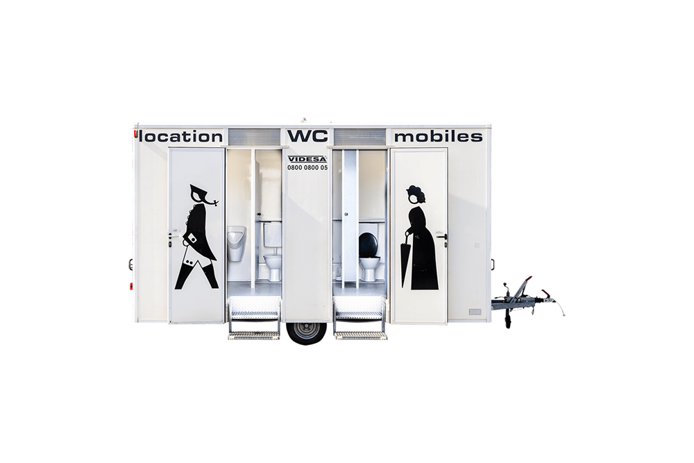 Une remorque blanche avec deux toilettes et une femme tenant un parapluie.