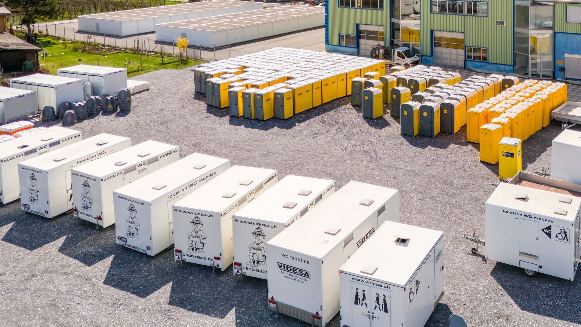 Beaucoup de conteneurs sont alignés sur un parking.