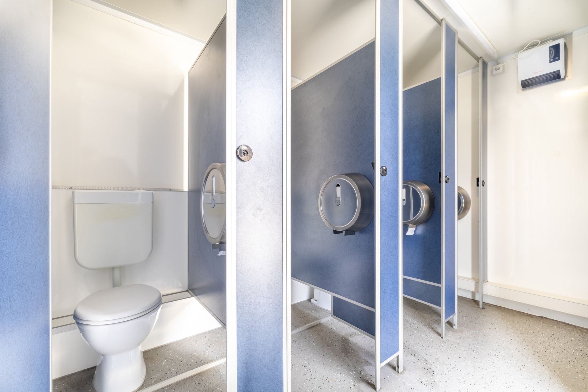 Des toilettes dans des toilettes publiques avec des séparateurs bleus.