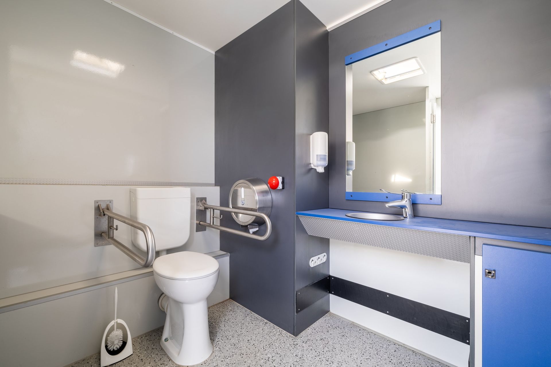 Une salle de bain avec WC, lavabo et miroir.