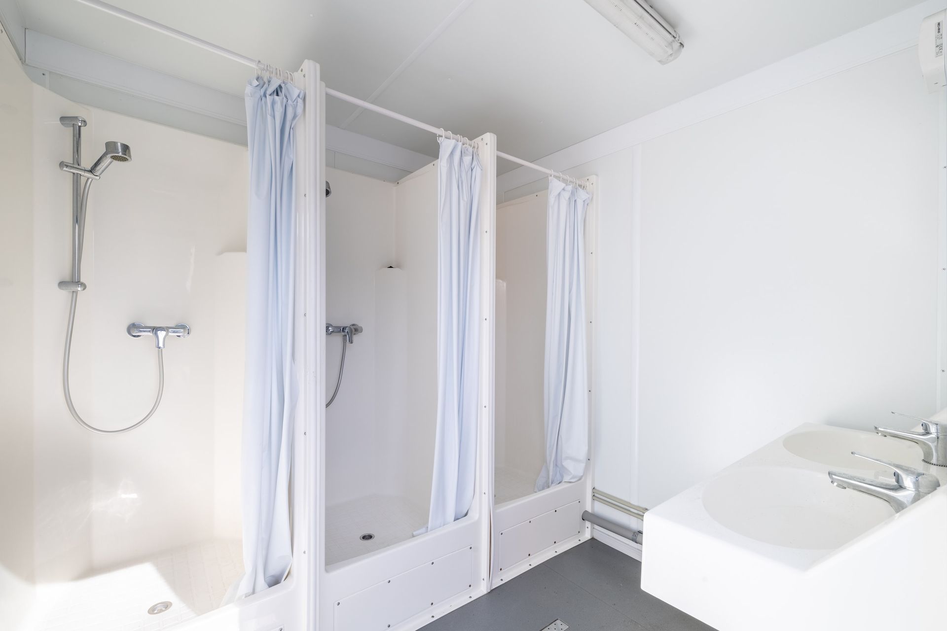 Une salle de bain avec deux douches et un lavabo.