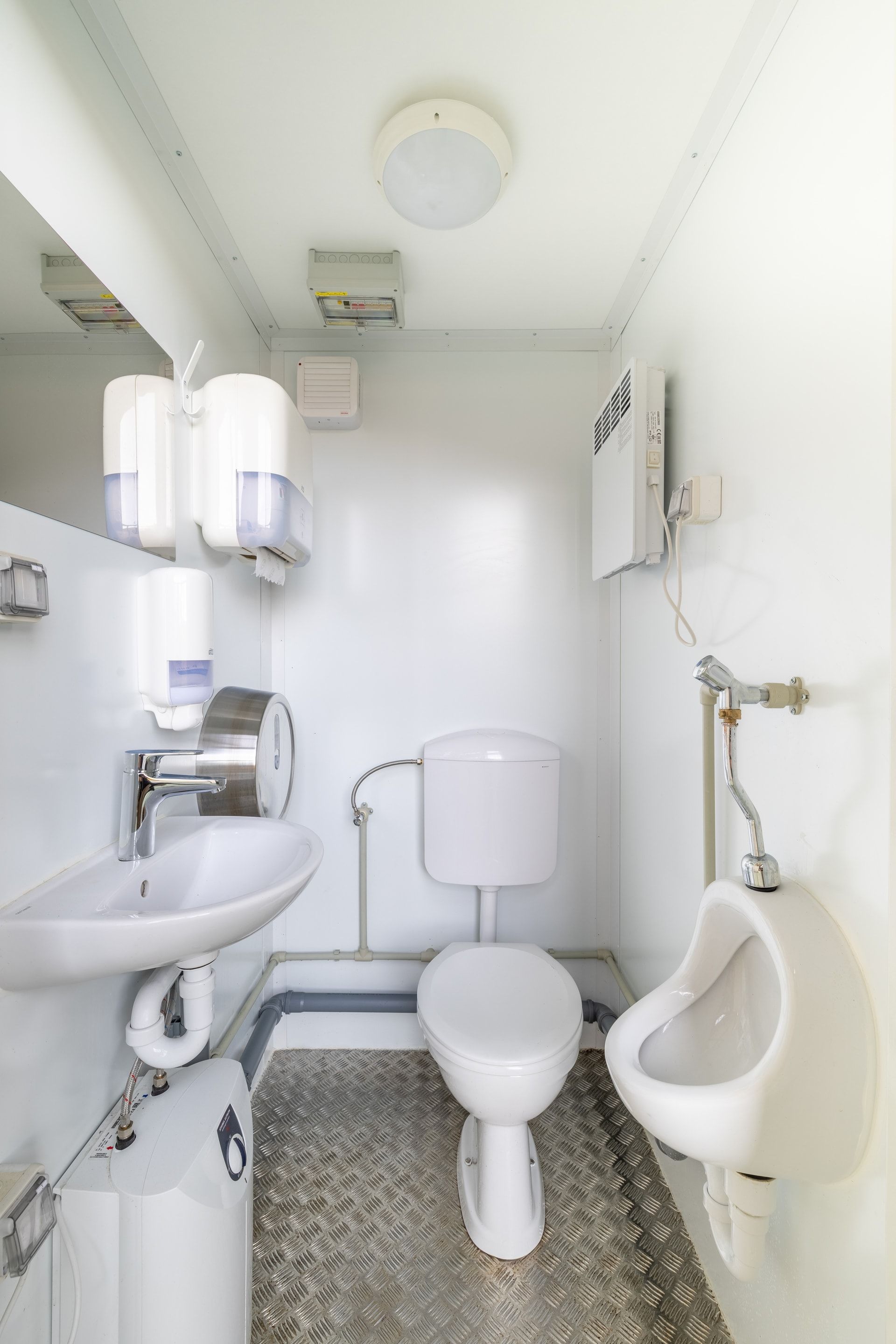 Une salle de bain avec WC, lavabo et urinoir.