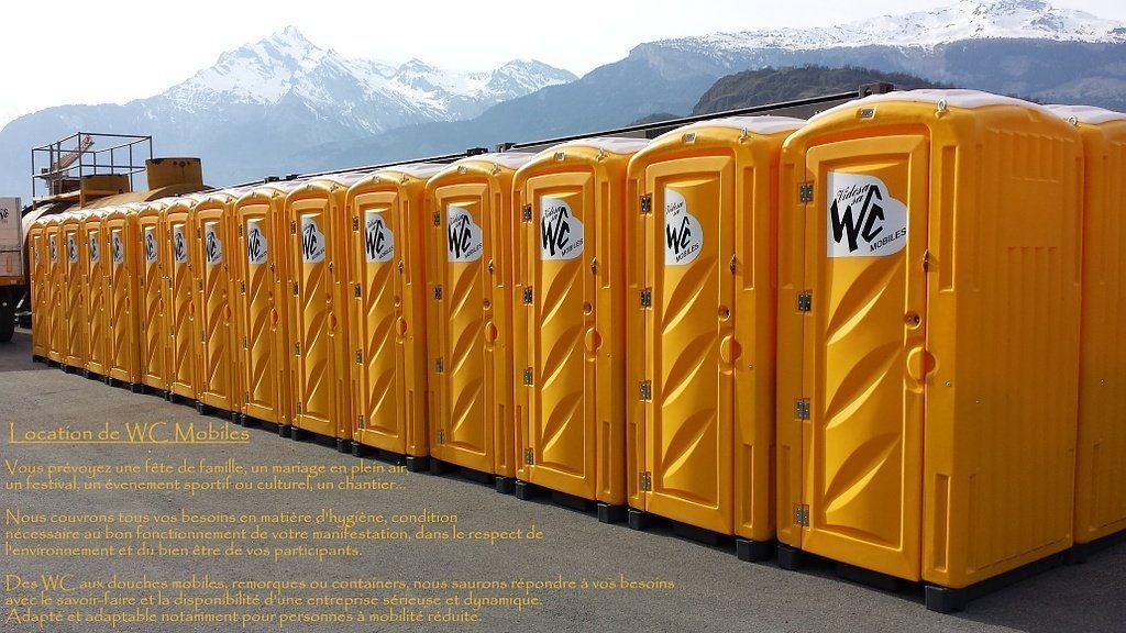 Une rangée de toilettes portables jaunes avec le mot wc sur la porte