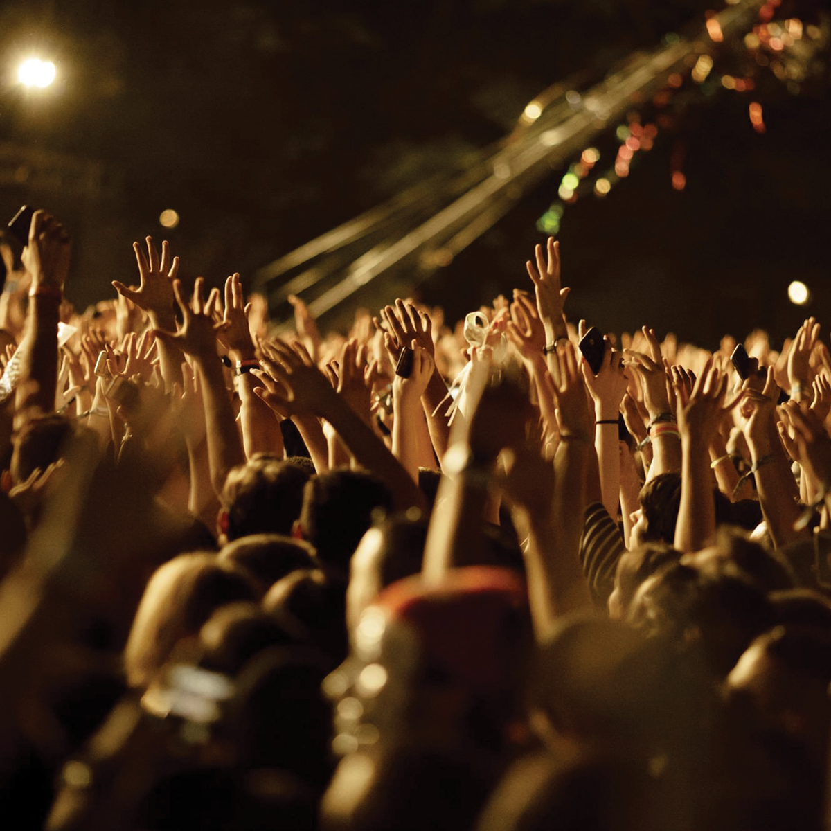 Une foule de gens avec les mains en l'air lors d'un concert