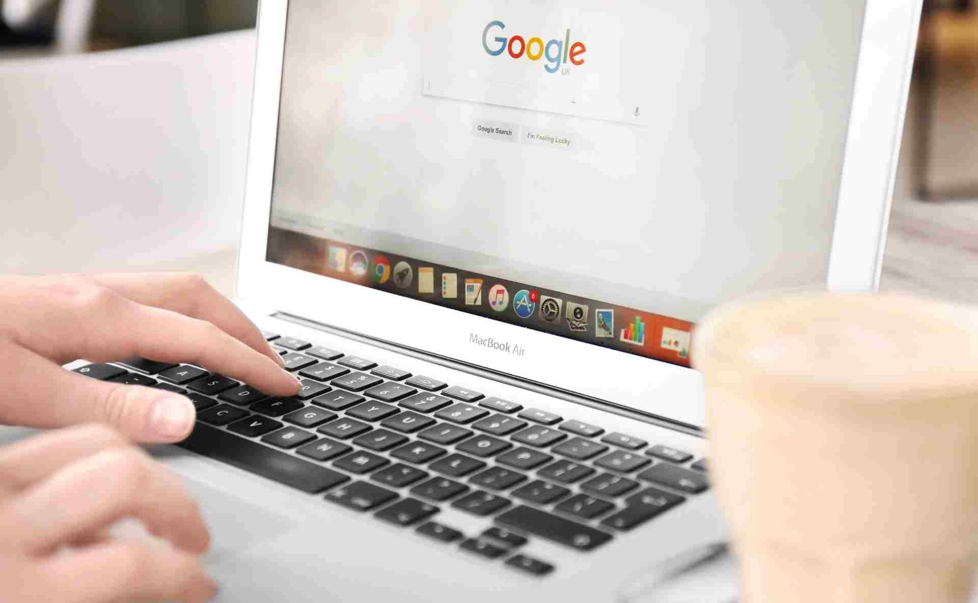 Person searching on Google laptop for local business optimization tips in 2026