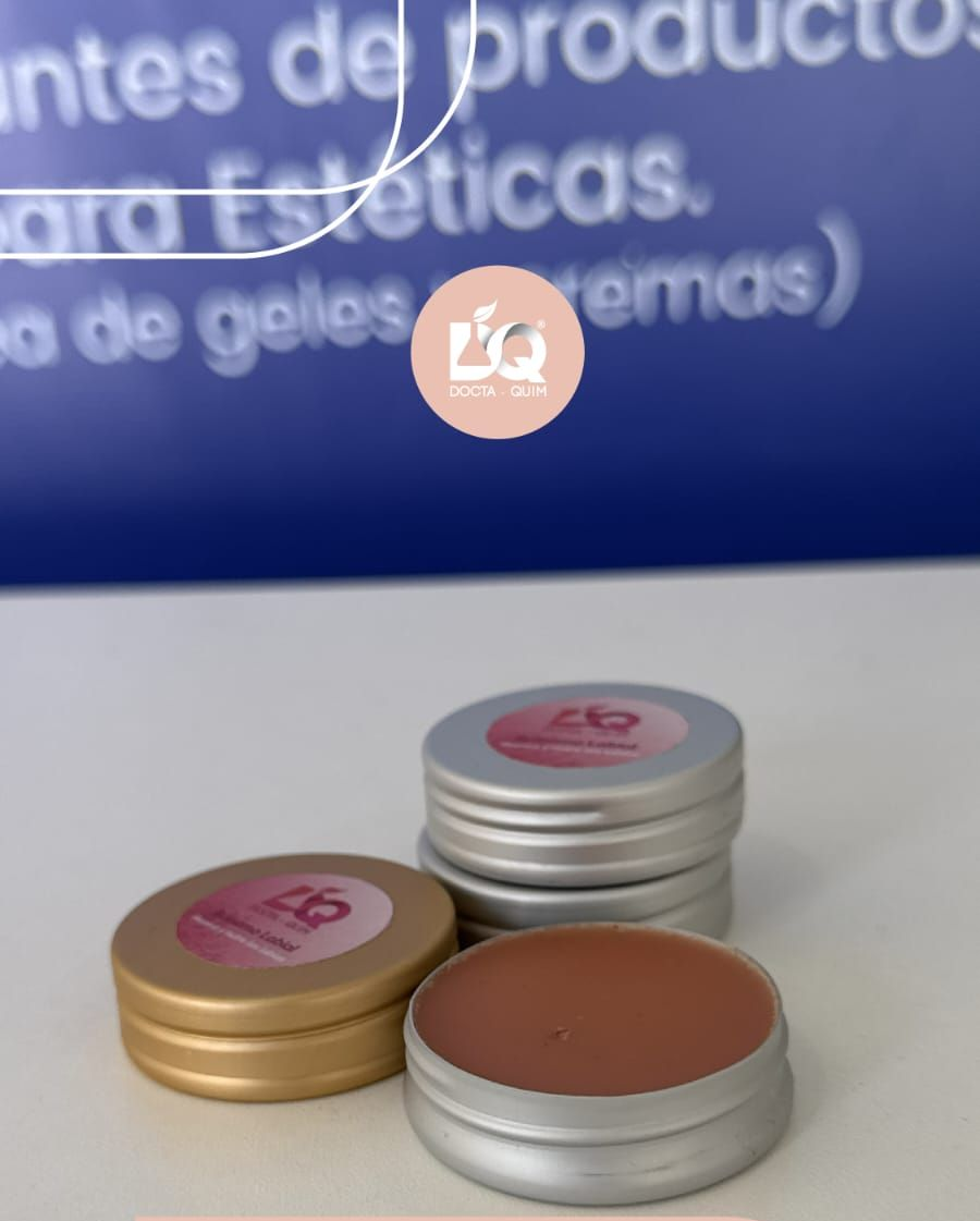 Montón de envases de cosméticos negros, dorados y rosas con etiquetas y texto rosas.