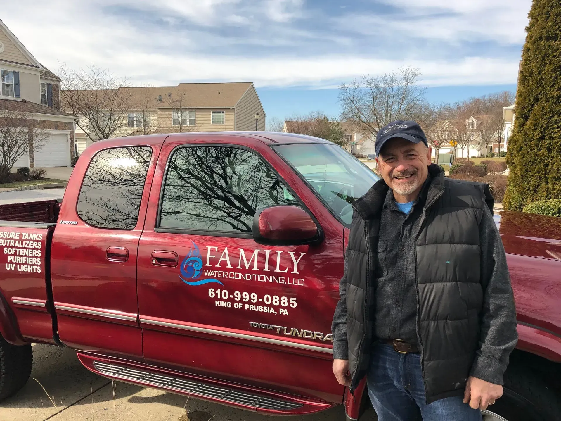 Man stands beside a red pickup truck with the 
