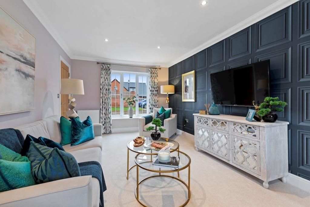 A living room with a couch , two coffee tables , and a flat screen tv.