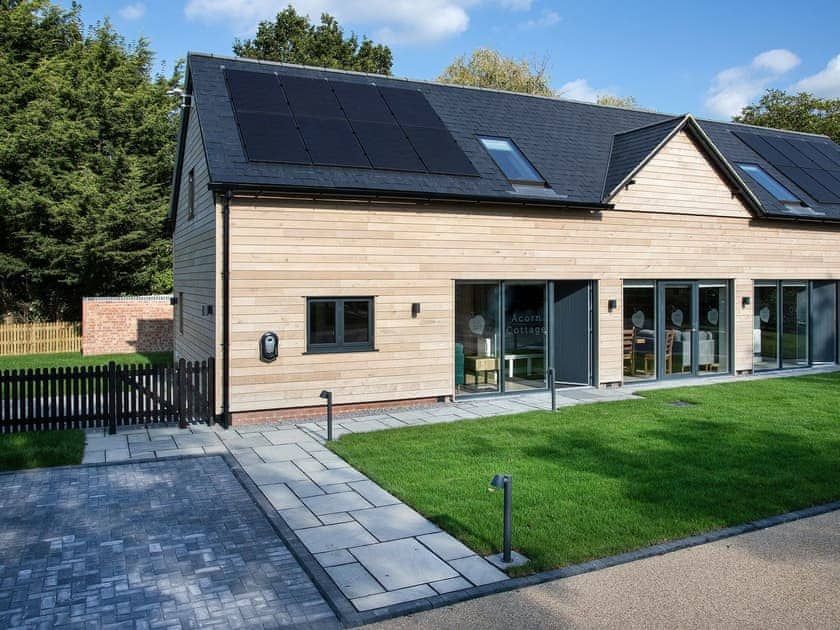 Sapphire Barn, A house with a lot of windows and solar panels on the roof.