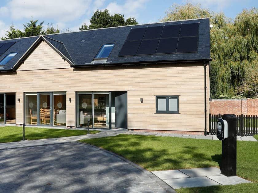 Sapphire Barn, A house with a lot of windows and solar panels on the roof