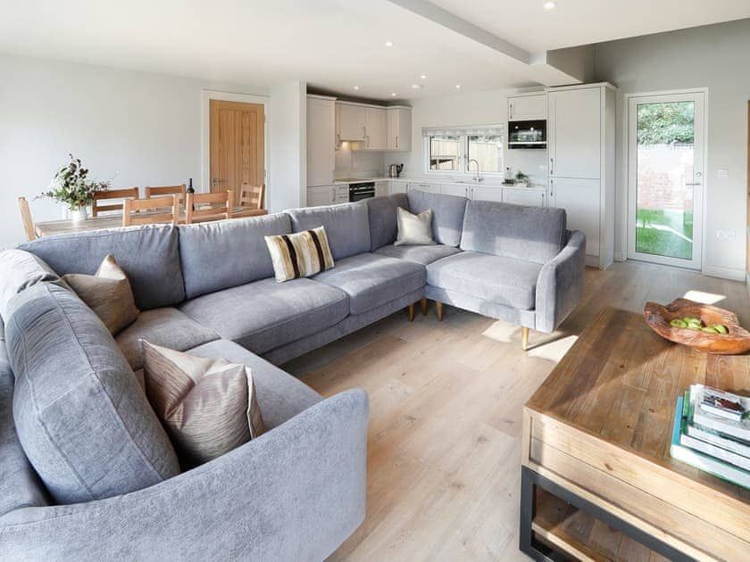 Sapphire Barn, A living room with a large sectional couch and a coffee table.