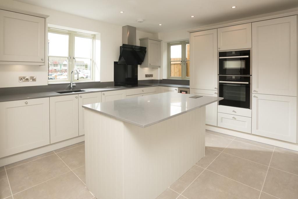 Brailes, A kitchen with white cabinets and a large island in the middle.