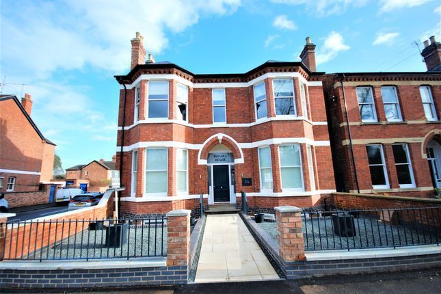 34 Lillington Road, a large brick house with a fence around it and a blue sky in the background.