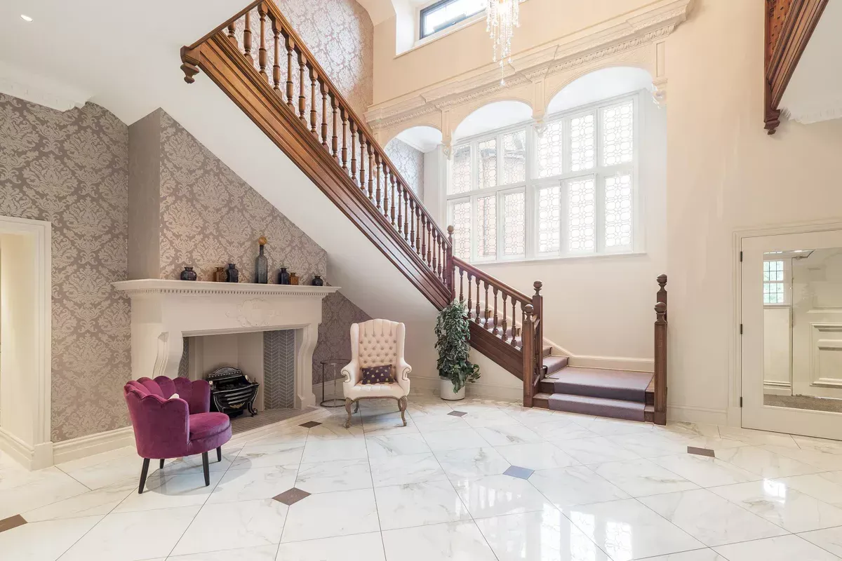 Milverton Hall, a large hallway with a staircase and a fireplace