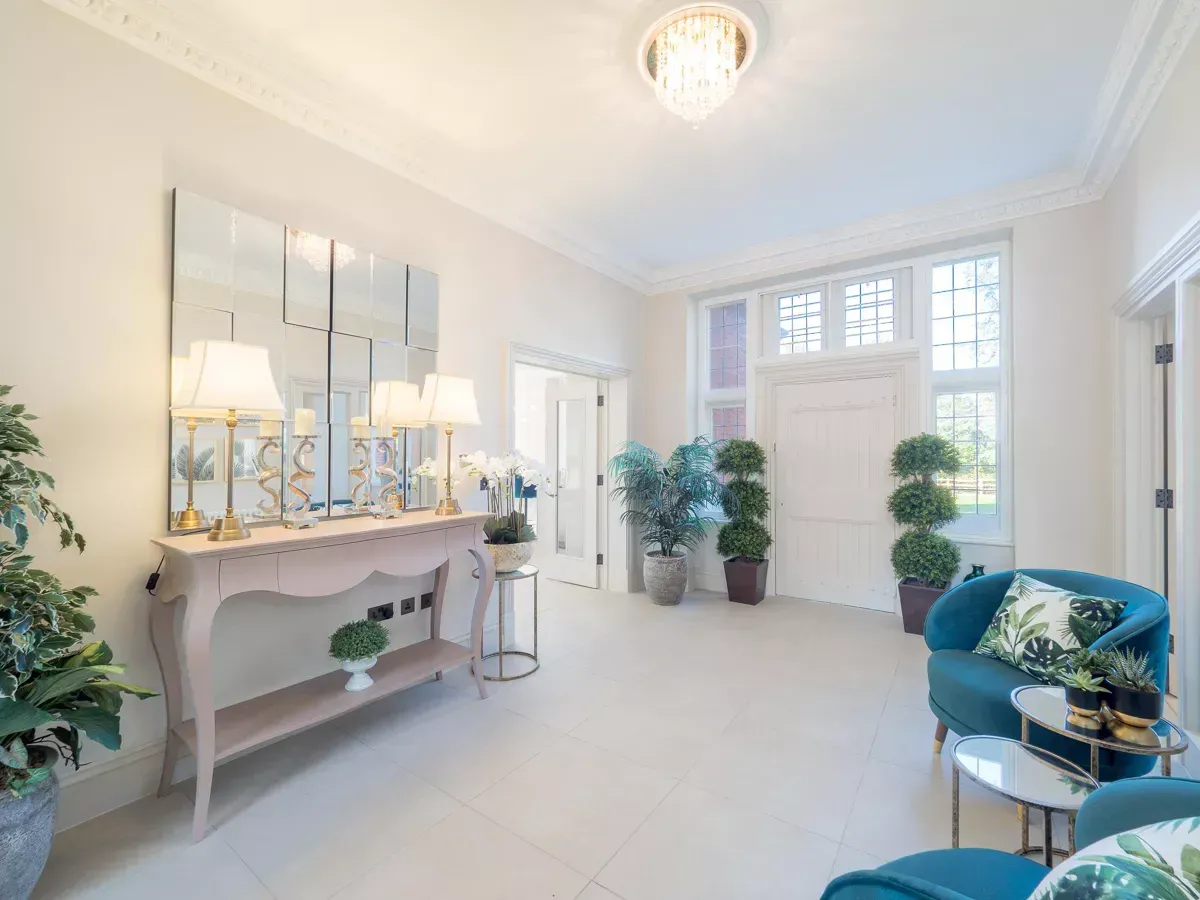 Milverton Hall, A living room with a couch , chair , table and mirror.