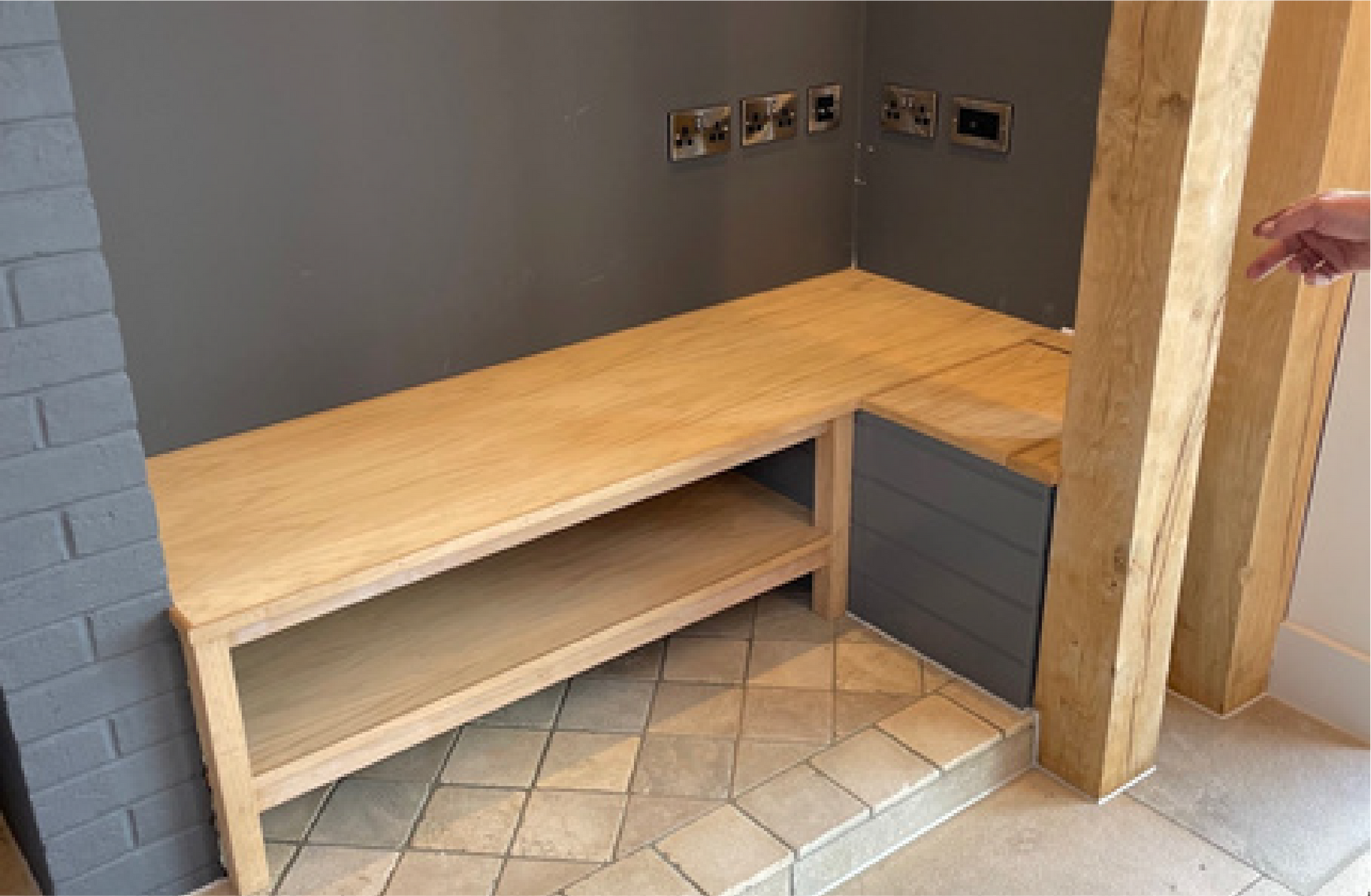 Kingfisher Barn,  A person is pointing at a wooden bench in a room.