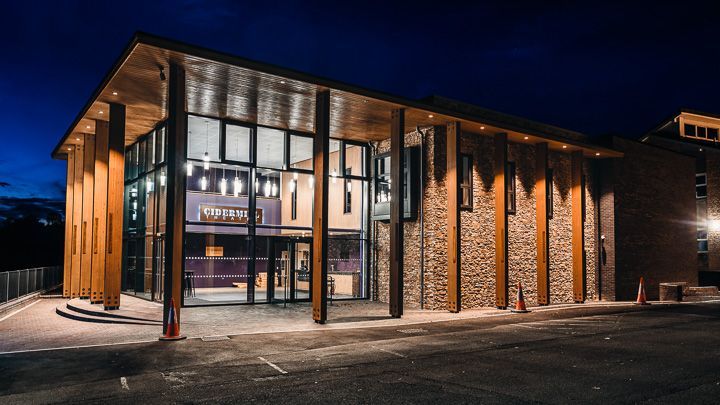 Chpping Campden, A large building with a lot of windows is lit up at night.