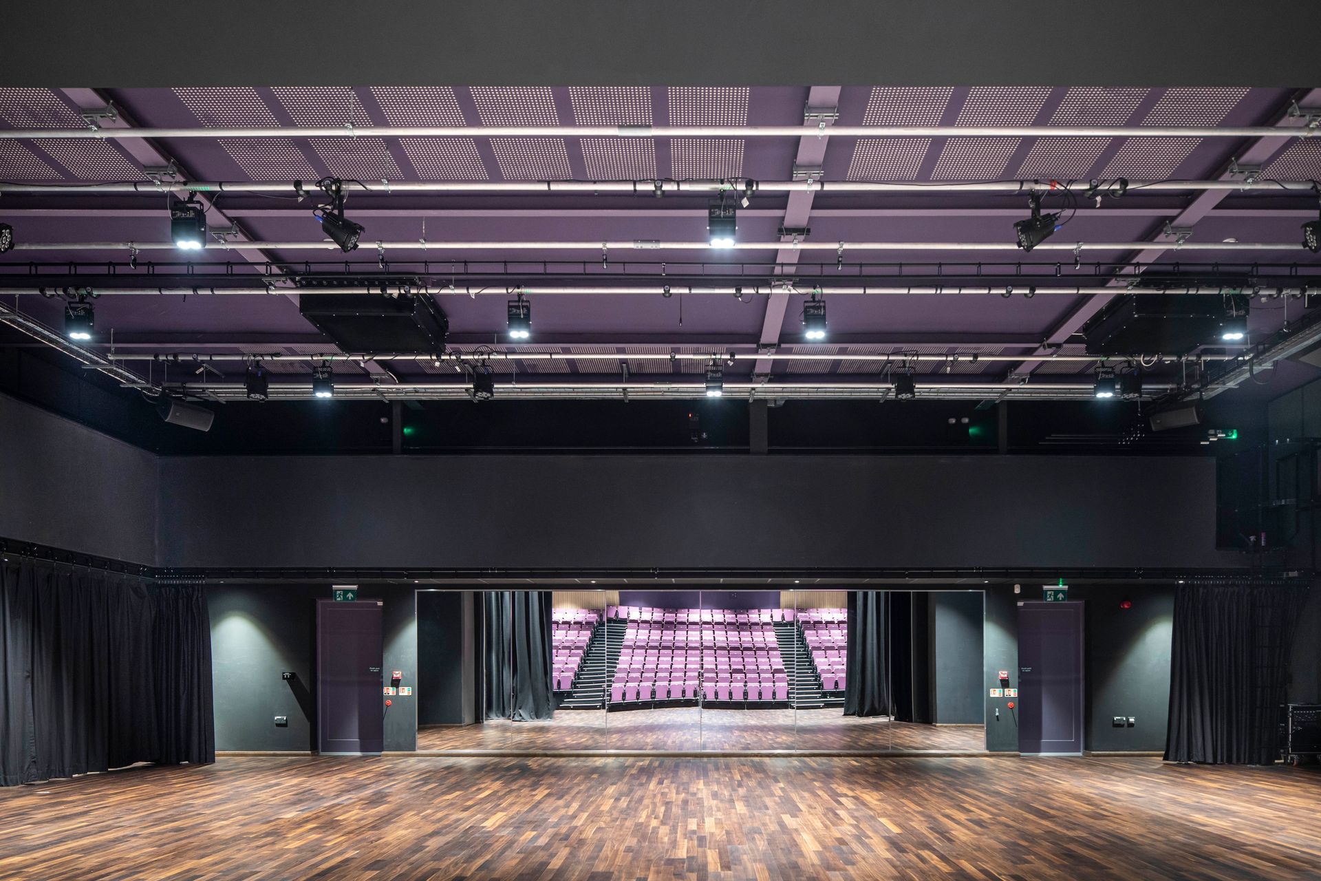 Chipping Campden, A large empty auditorium with a wooden floor and purple curtains.