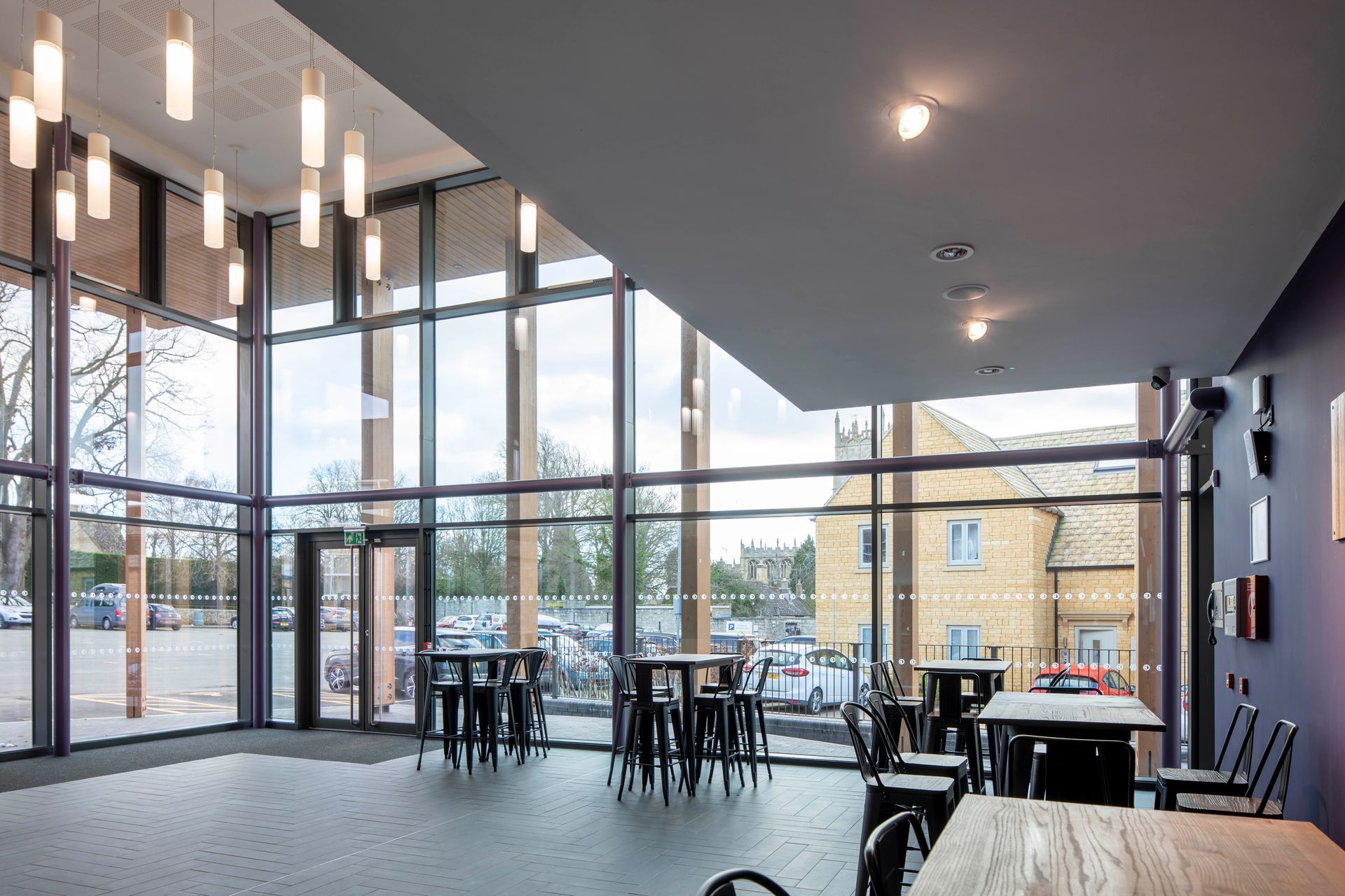 Chipping Campden, A large room with tables and chairs in front of a large window.